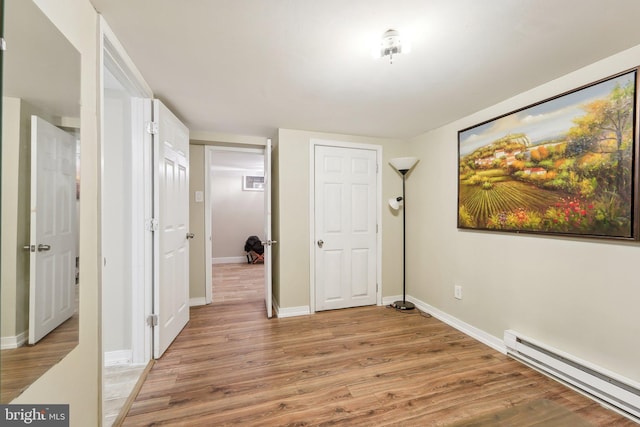 interior space with a baseboard radiator and light hardwood / wood-style floors