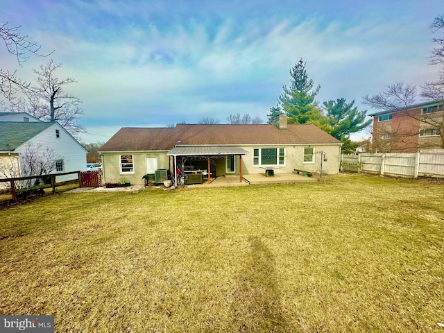 rear view of house with central AC unit, a yard, and a patio