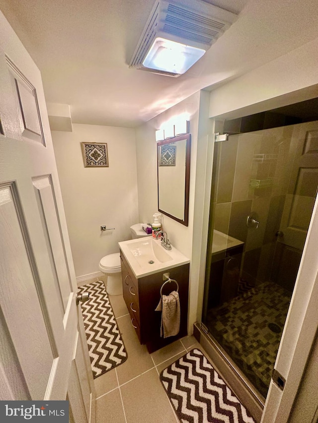 bathroom featuring tile patterned floors, toilet, a shower with shower door, and vanity