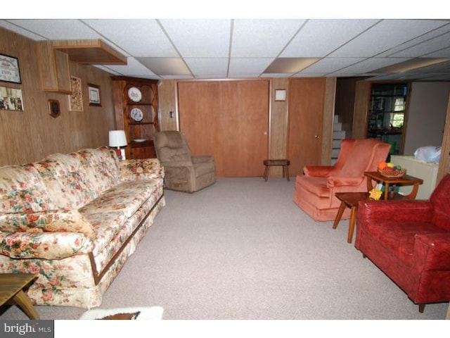 living room featuring wooden walls and light carpet