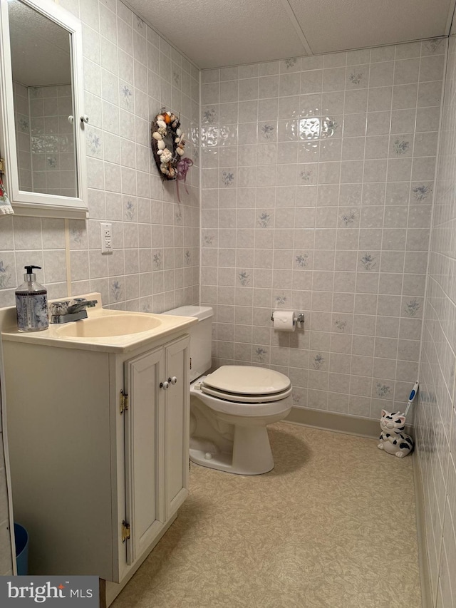 bathroom with tile walls, toilet, decorative backsplash, and vanity