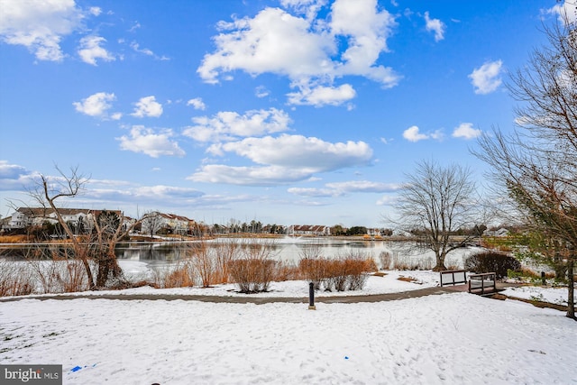 snowy yard featuring a water view