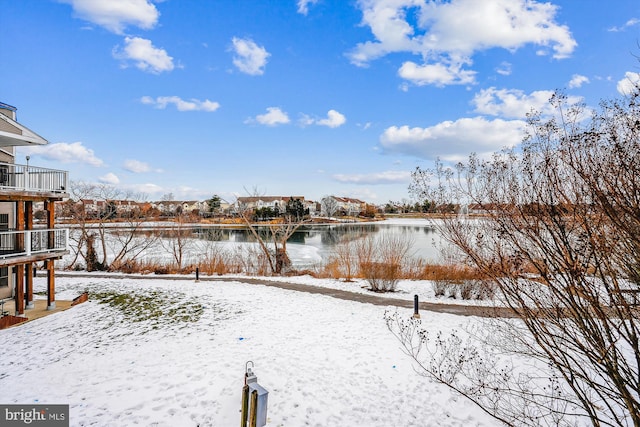 yard covered in snow with a water view