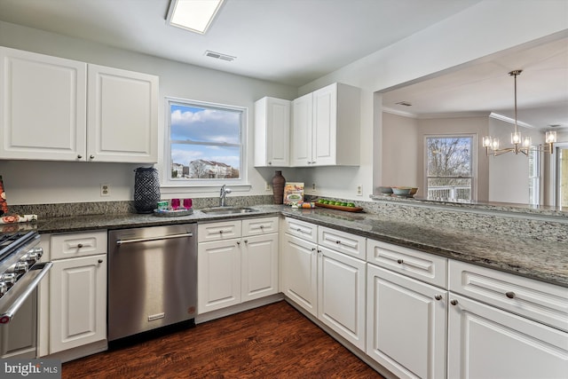 kitchen with stainless steel appliances, white cabinets, dark stone counters, and a notable chandelier