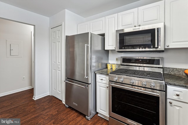 kitchen featuring white cabinets, stainless steel appliances, dark stone counters, dark hardwood / wood-style floors, and electric panel