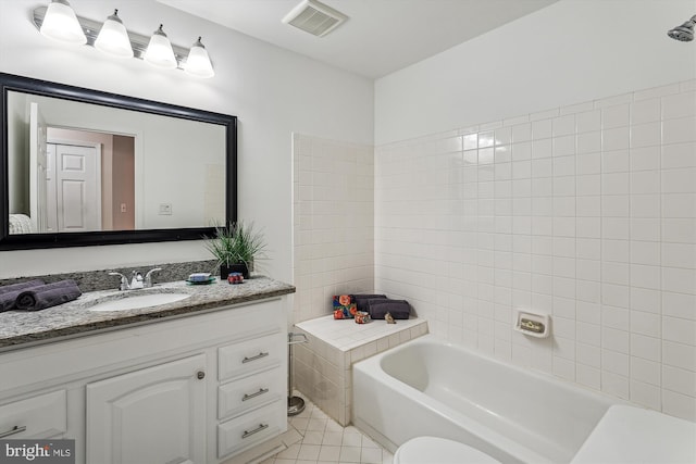 bathroom featuring toilet, tile patterned flooring, a tub to relax in, and vanity