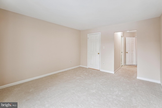 spare room featuring light carpet