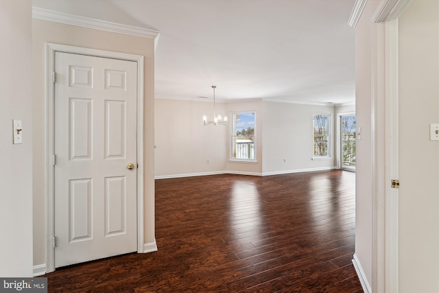 unfurnished room with dark wood-type flooring, an inviting chandelier, and ornamental molding