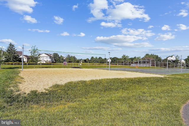 view of home's community with a rural view, volleyball court, basketball court, and a lawn