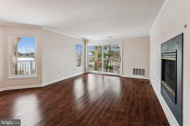 unfurnished living room featuring dark hardwood / wood-style flooring, ornamental molding, and plenty of natural light