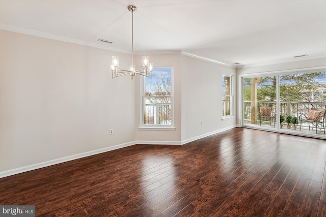 unfurnished room with crown molding, dark hardwood / wood-style floors, and an inviting chandelier