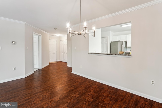 unfurnished dining area featuring dark wood-type flooring, ornamental molding, and an inviting chandelier