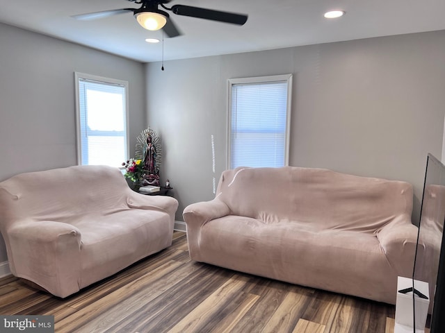 living room featuring wood-type flooring and ceiling fan