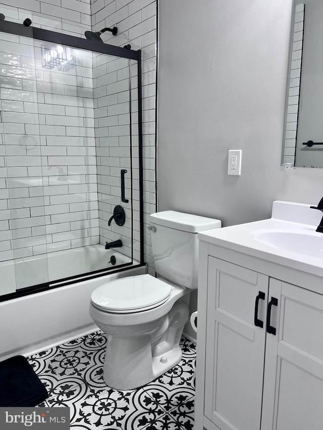 full bathroom featuring enclosed tub / shower combo, vanity, and toilet