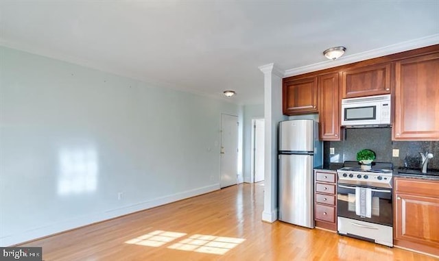 kitchen featuring stainless steel refrigerator, light wood-type flooring, decorative backsplash, and range with electric stovetop