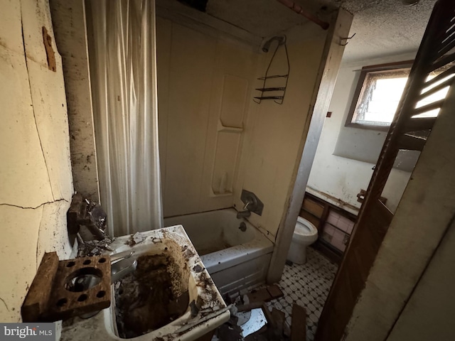 full bathroom featuring sink, shower / bath combo, a textured ceiling, and toilet