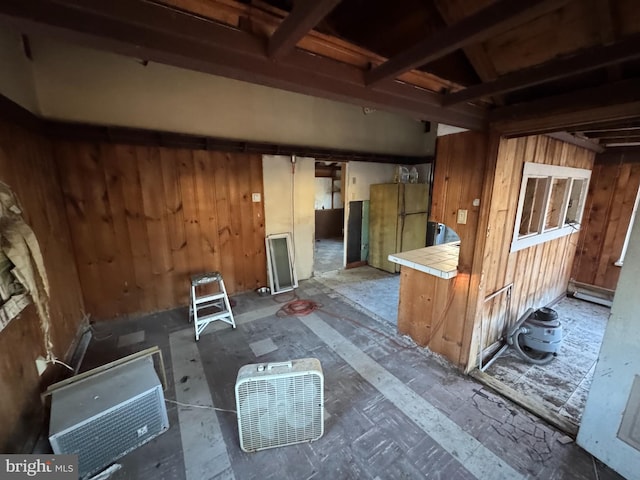 kitchen featuring fridge, wood walls, and tile counters