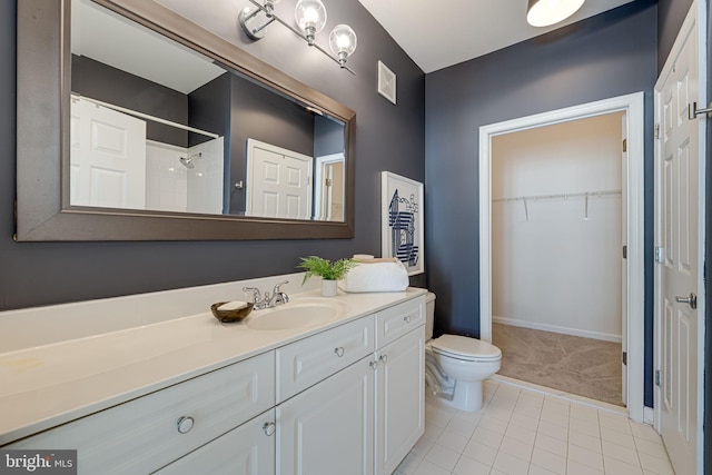 bathroom featuring vanity, walk in shower, tile patterned floors, and toilet