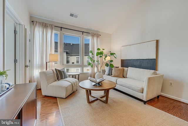 living room with hardwood / wood-style flooring and vaulted ceiling