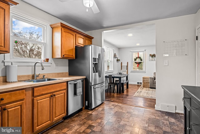 kitchen featuring stainless steel appliances, ceiling fan, sink, and plenty of natural light