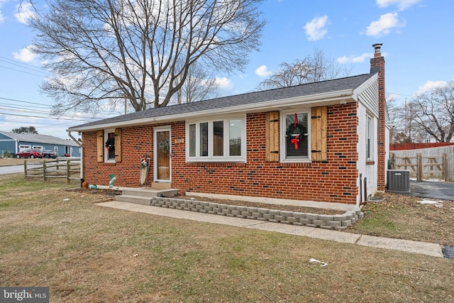 view of front facade featuring a front lawn and central AC