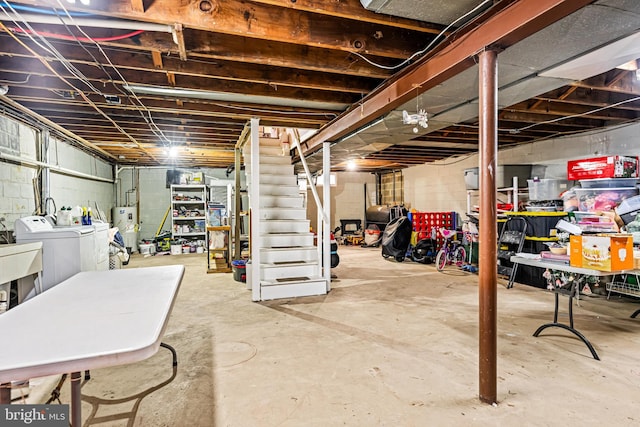 basement with electric water heater and washer and clothes dryer