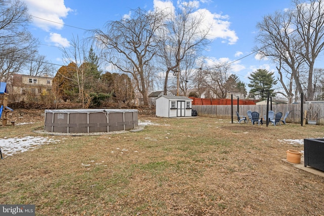 view of yard with a storage unit, cooling unit, and a fenced in pool