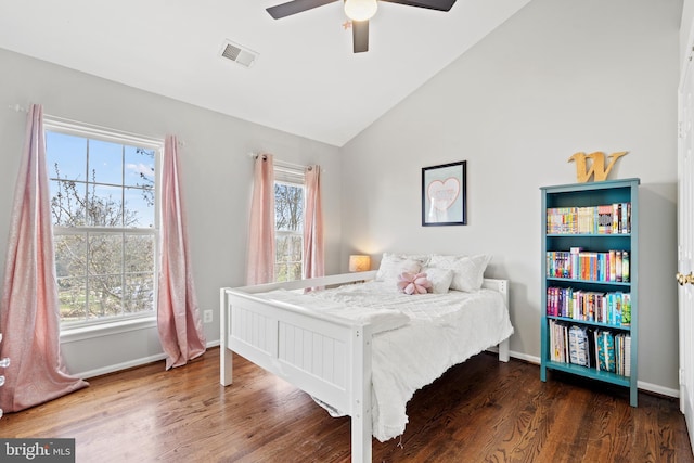 bedroom with ceiling fan, multiple windows, dark hardwood / wood-style floors, and vaulted ceiling