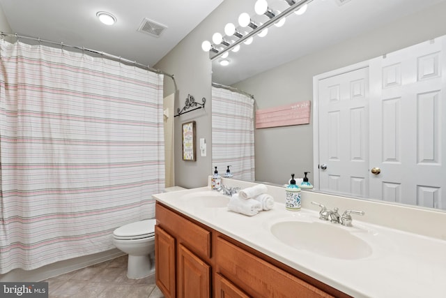 bathroom featuring toilet, tile patterned flooring, vanity, and curtained shower