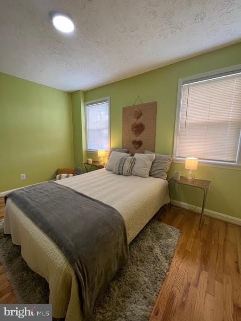 bedroom featuring a textured ceiling and light hardwood / wood-style floors