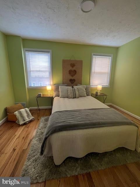 bedroom featuring a textured ceiling and hardwood / wood-style floors