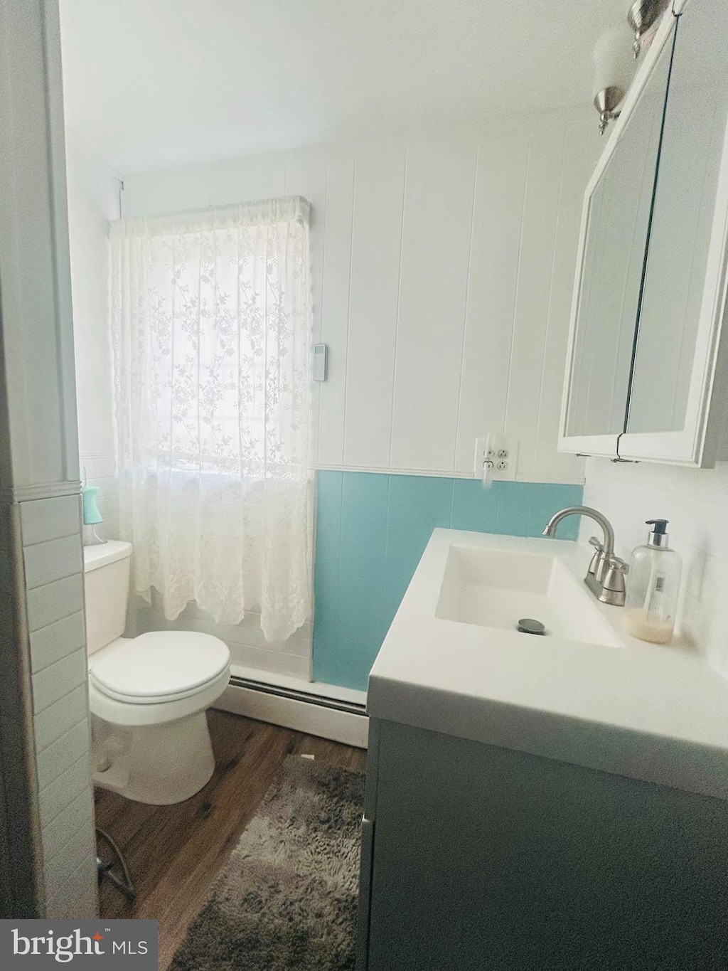 bathroom featuring toilet, a baseboard radiator, vanity, and hardwood / wood-style flooring