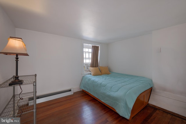 bedroom with baseboard heating and dark wood-type flooring