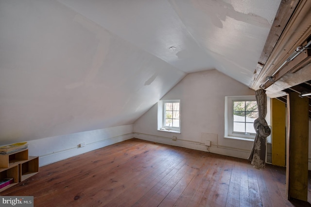 additional living space featuring lofted ceiling, wood-type flooring, and plenty of natural light