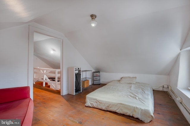 bedroom with vaulted ceiling and wood-type flooring