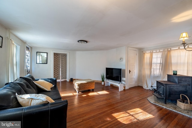 living room with a wealth of natural light, a wood stove, and dark hardwood / wood-style floors