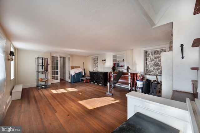 living room featuring dark wood-type flooring and built in shelves