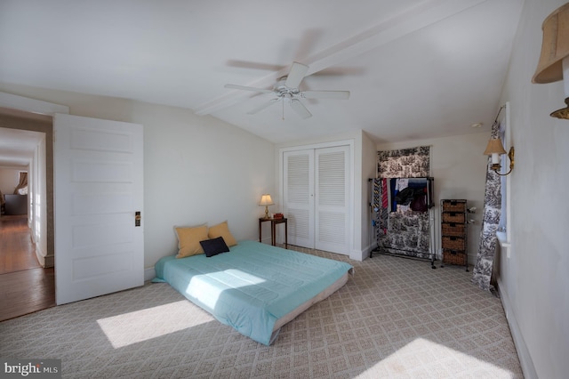 carpeted bedroom featuring ceiling fan, a closet, and lofted ceiling with beams