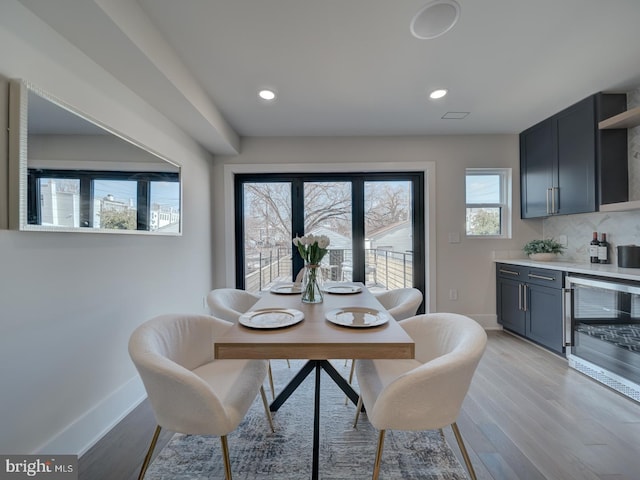 dining area featuring beverage cooler and light wood-type flooring