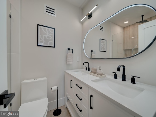 bathroom featuring vanity, toilet, and walk in shower