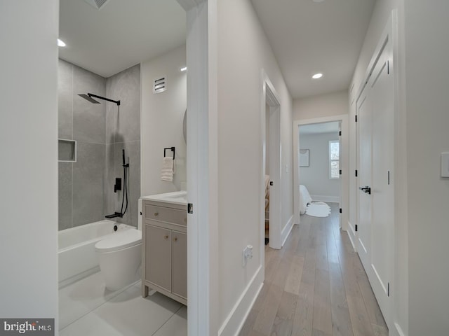 bathroom featuring vanity, hardwood / wood-style flooring, and tiled shower / bath