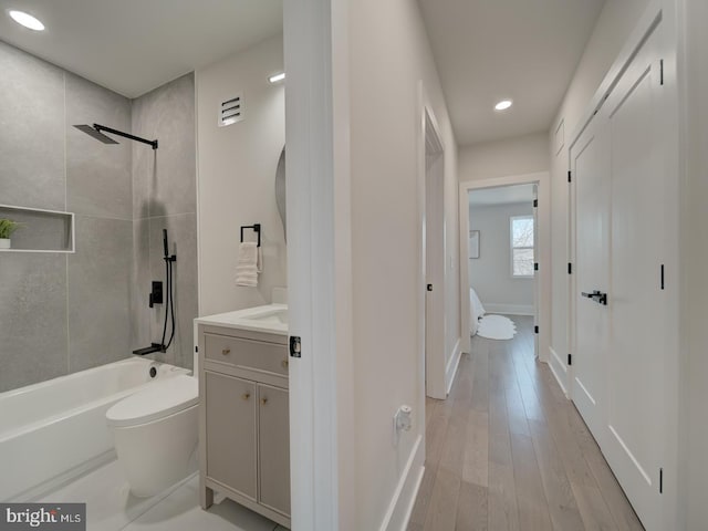 bathroom with vanity, hardwood / wood-style floors, and tiled shower / bath