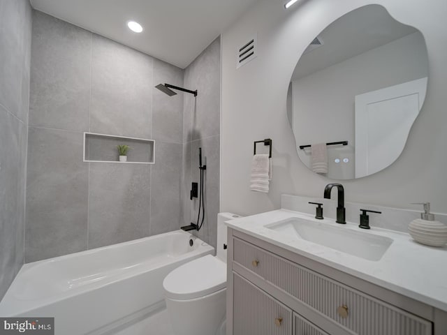 full bathroom with tiled shower / bath, vanity, and toilet