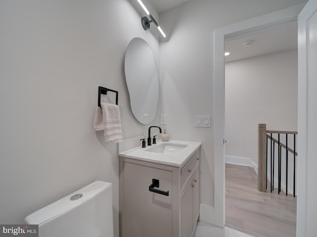 bathroom featuring vanity, hardwood / wood-style flooring, and toilet