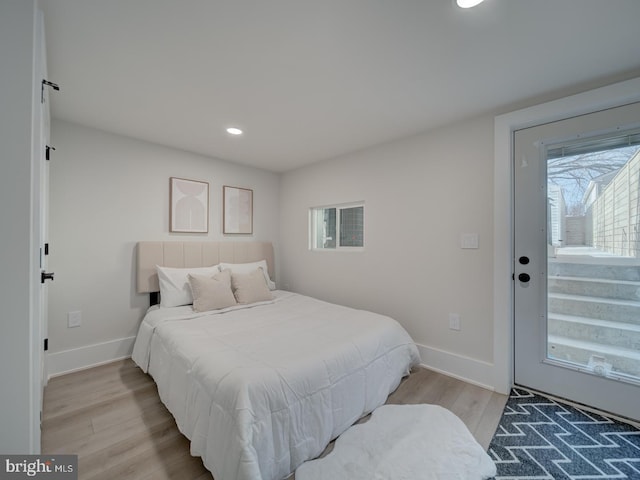 bedroom with light wood-type flooring and access to outside