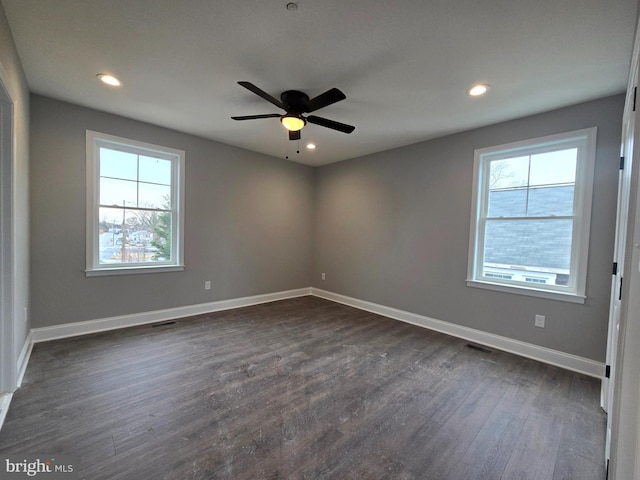 unfurnished room featuring a healthy amount of sunlight, baseboards, dark wood-style flooring, and recessed lighting