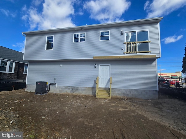 rear view of house featuring entry steps and central AC