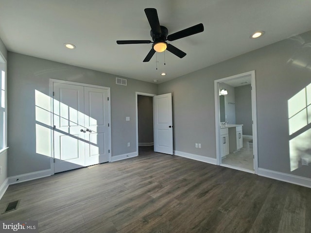 unfurnished bedroom featuring baseboards, visible vents, dark wood-type flooring, and recessed lighting