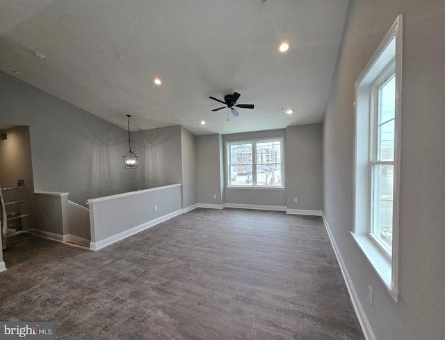 unfurnished living room with recessed lighting, dark wood-style flooring, and baseboards