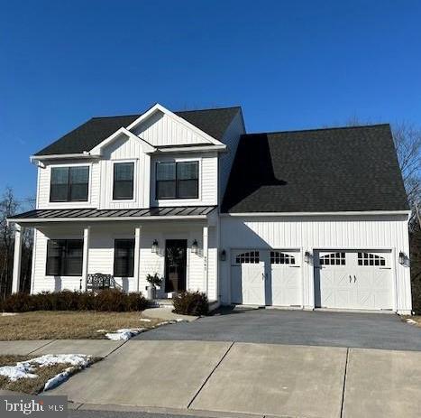 modern inspired farmhouse with a porch and a garage